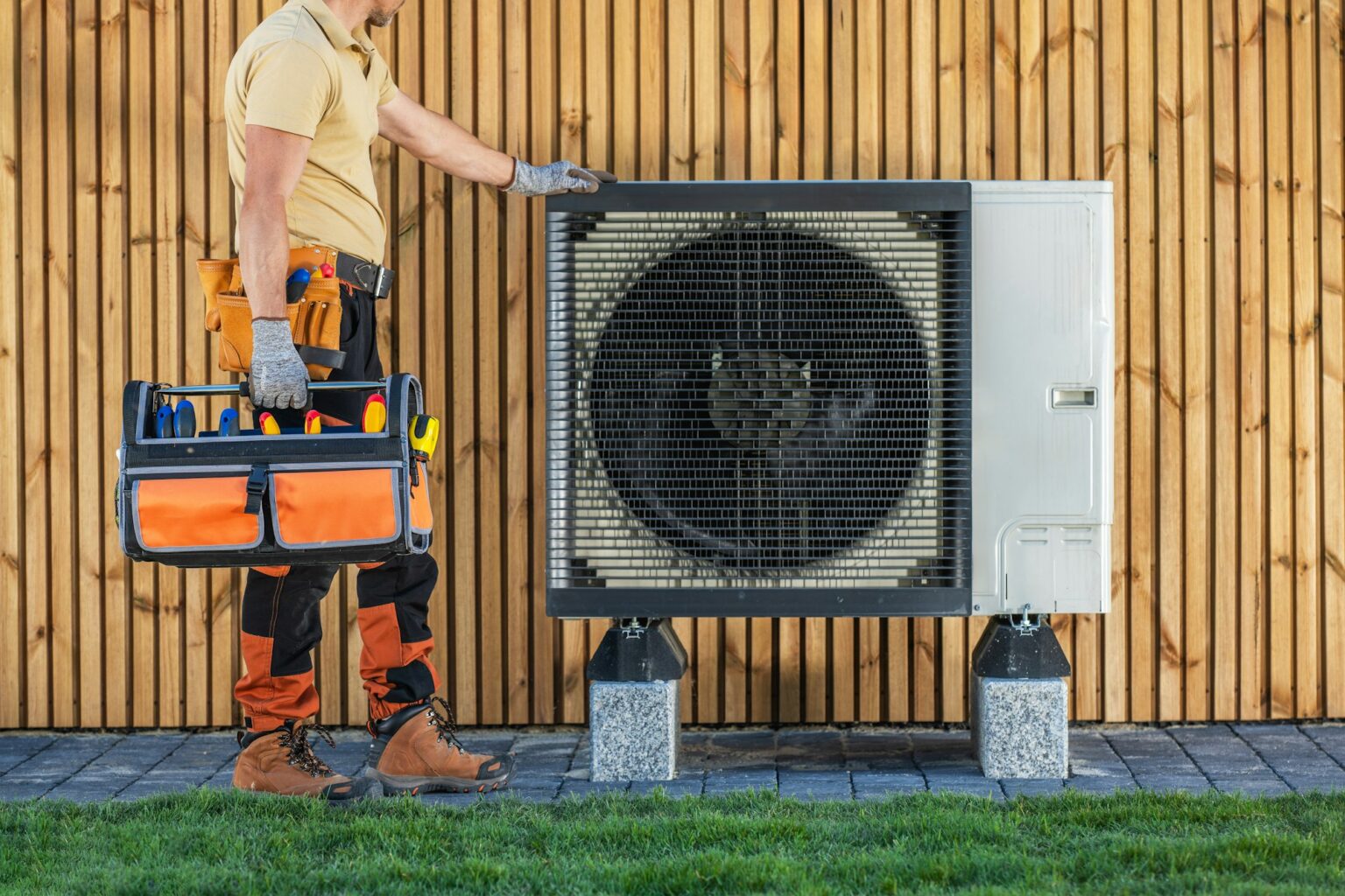 HVAC Technician Standing by Air Conditioning Unit Preparing For Maintenance.