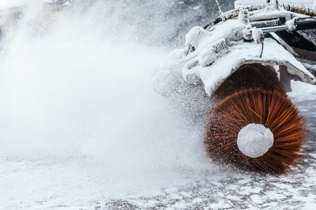 Snow plow does removal after blizzard in winter. Snow blower in motorway. Winter service on road