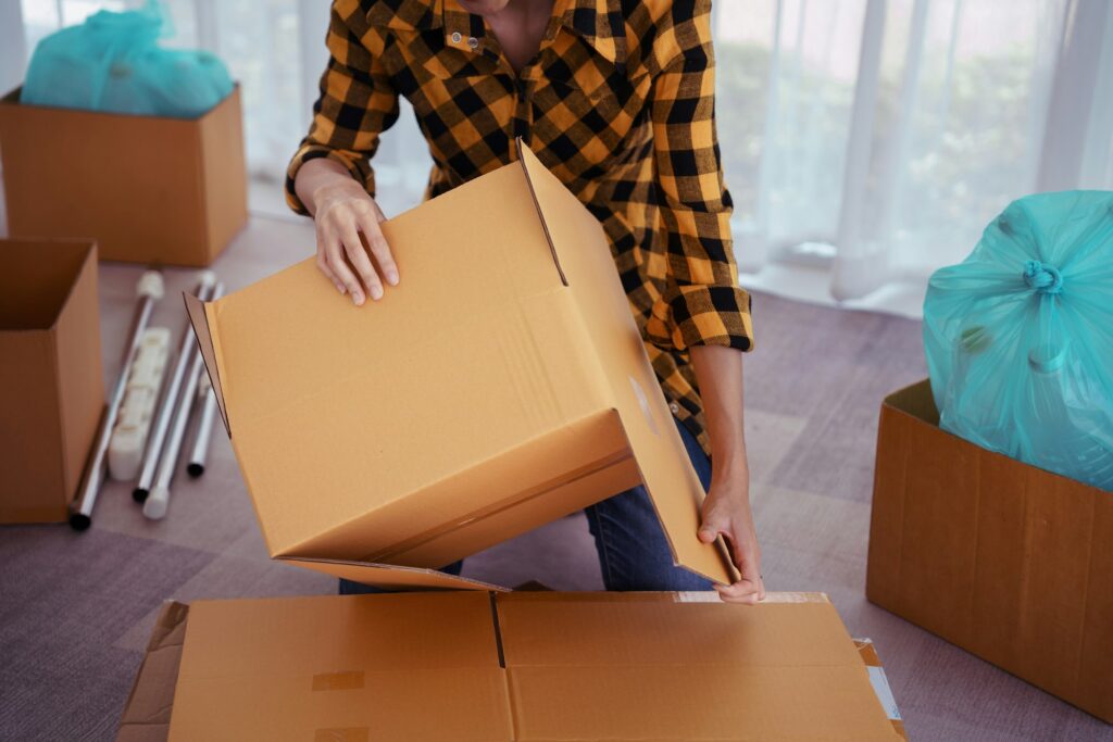 Women picking and sorting waste cardboard box to reuse and recycling for conservation environment